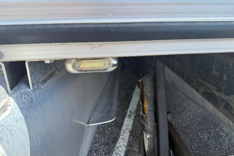 Slide: The Image of 2019 Crestliner 200 Rally DX CWDH boat detail showing a side light and trailer components. - 24