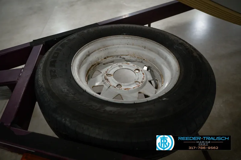 Slide: The Image of Rusty wheel on a 1998 Nitro 700 LX SC trailer, displayed indoors. - 60