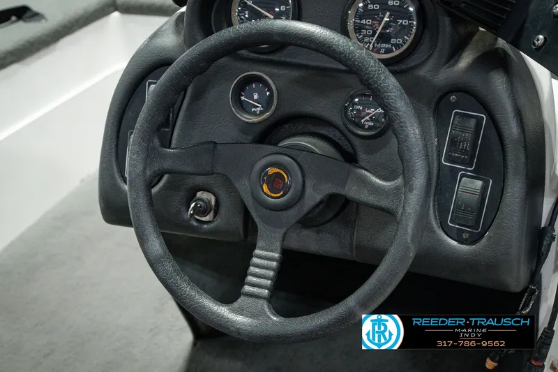 Slide: The Image of Steering wheel and dashboard of a 1998 Nitro 700 LX SC boat, featuring gauges and controls. - 29