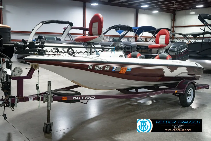 Slide: The Image of 1998 Nitro 700 LX SC boat on trailer in showroom, featuring Minn Kota motor. - 1