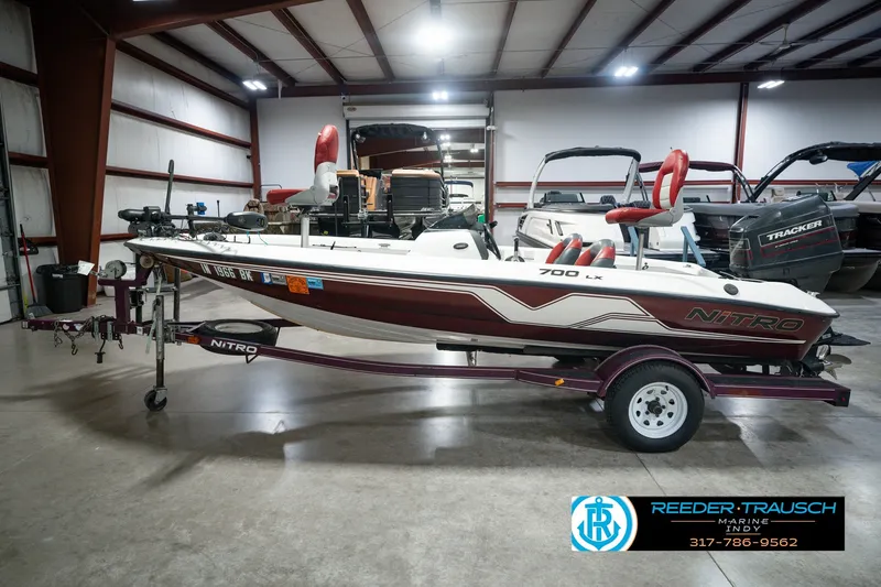 Slide: The Image of 1998 Nitro 700 LX SC boat in showroom, red and white design, on trailer. - 10