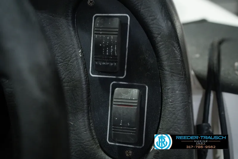 Slide: The Image of Close-up of 1998 Nitro 700 LX SC dashboard switches with textured black surface. - 38