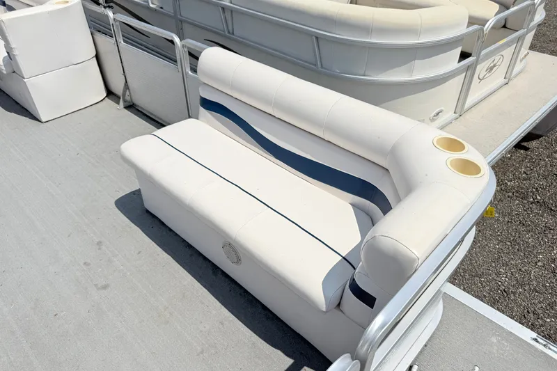 Slide: The Image of 2001 Harris Cruiser 220 boat seating with cup holders, featuring white and blue upholstery. - 5