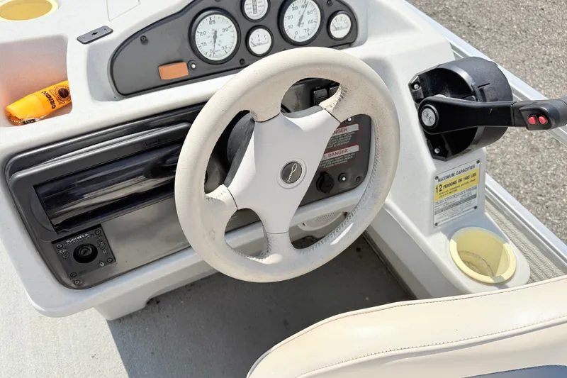 Slide: The Image of Steering console of a 2001 Harris Cruiser 220 boat with gauges and controls. - 14