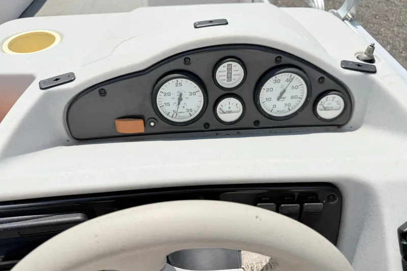 Slide: The Image of Dashboard of a 2001 Harris Cruiser 220 boat with gauges and steering wheel. - 11