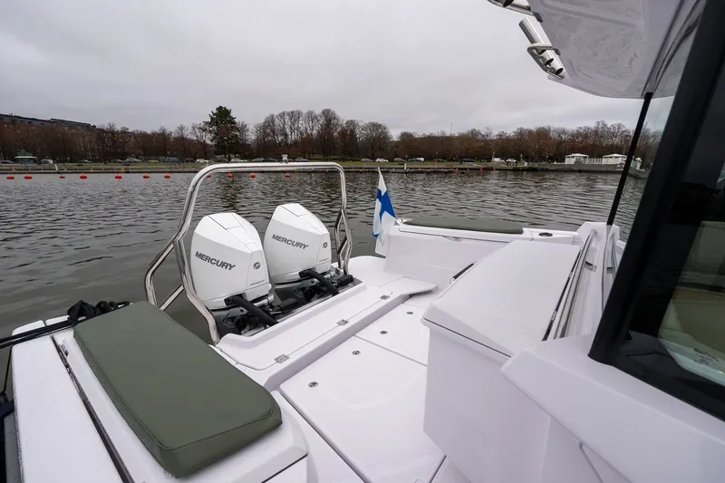 Slide: The Image of 2027 Axopar 38 Cross Cabin boat with dual Mercury engines on a calm lake. - 11