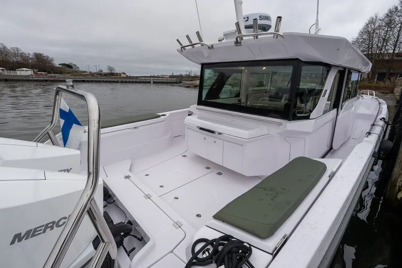 Slide: The Image of 2027 Axopar 38 Cross Cabin boat docked, featuring spacious deck and modern design. - 5