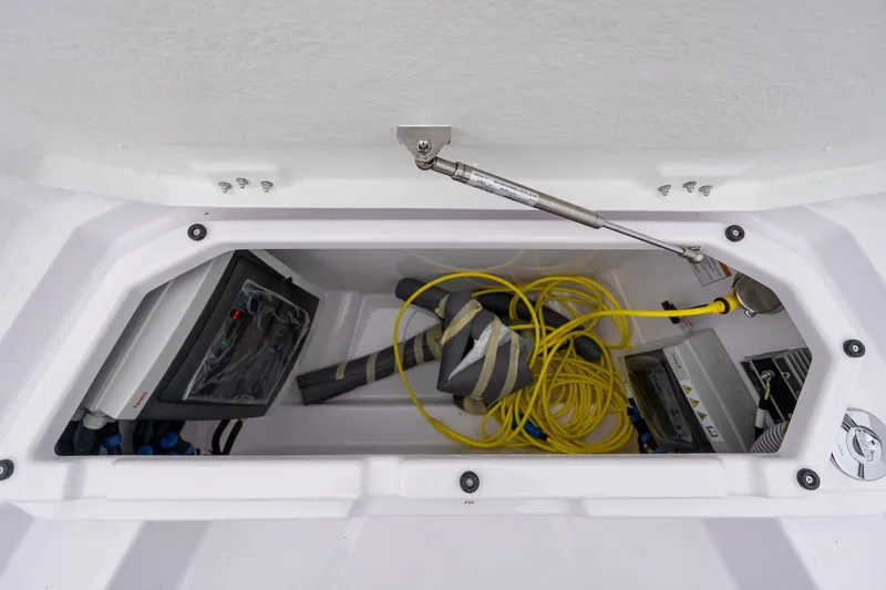 Slide: The Image of Storage compartment of 2027 Axopar 38 Cross Cabin with equipment and yellow cable. - 27