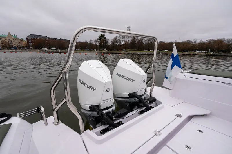 Slide: The Image of 2027 Axopar 38 Cross Cabin with dual Mercury engines on a calm lake. - 12