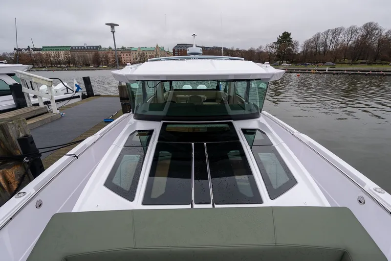Slide: The Image of 2027 Axopar 38 Cross Cabin docked by a scenic waterfront. - 30