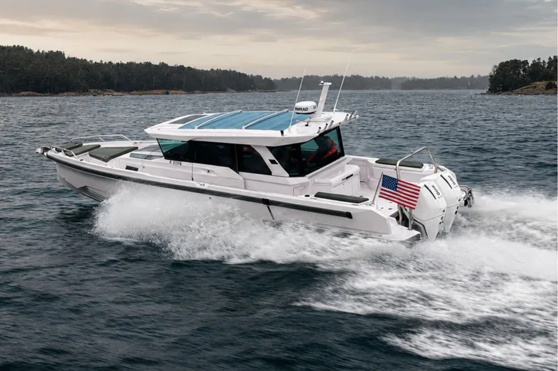 The Image of 2027 Axopar 38 Cross Cabin boat cruising on open water with American flag. - 0