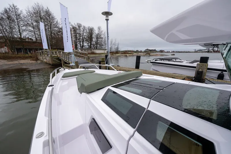 Slide: The Image of 2027 Axopar 38 Cross Cabin docked by a serene waterfront with overcast skies. - 20