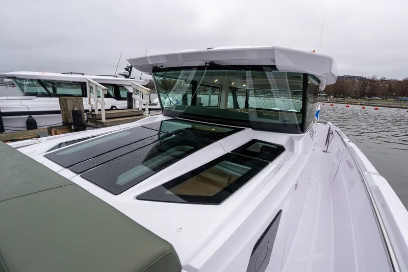 Slide: The Image of 2027 Axopar 38 Cross Cabin boat docked, showcasing sleek design and modern windows. - 31