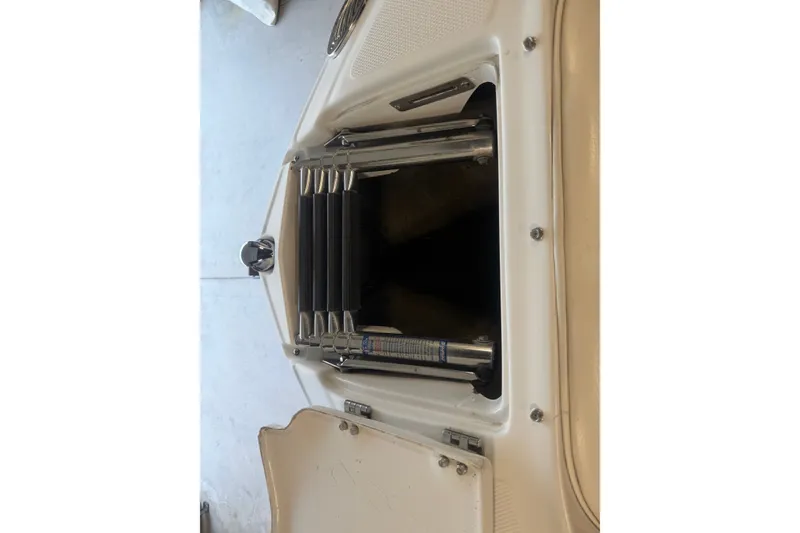 Slide: The Image of 2005 Crownline 226 LS boat ladder compartment, open view, showcasing stainless steel ladder. - 14