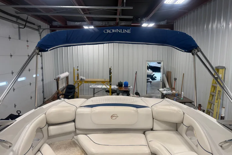 Slide: The Image of 2005 Crownline 226 LS boat interior with blue canopy in a garage setting. - 16