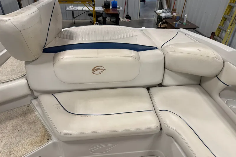 Slide: The Image of 2005 Crownline 226 LS boat interior with white cushioned seating and blue accents. - 20