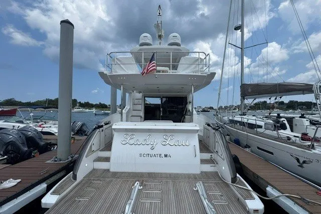 Slide: The Image of 2023 Azimut Fly 50 yacht docked, rear view with American flag, cloudy sky. - 5