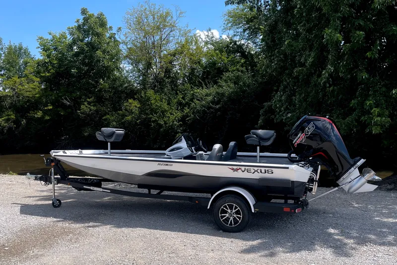 Slide: The Image of A 2023 Vexus AVX189C boat on a trailer, surrounded by trees and a river. - 3