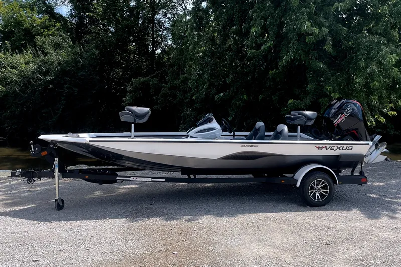 Slide: The Image of A 2023 Vexus AVX189C boat on a trailer, set against a wooded background. - 2