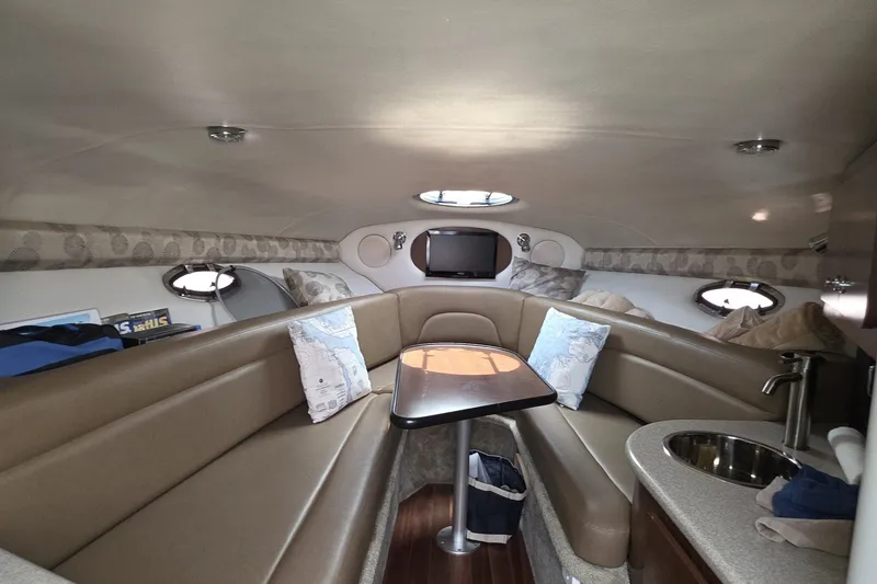 Slide: The Image of Interior of 2017 Crownline 325 SCR boat with seating, table, and kitchenette. - 29