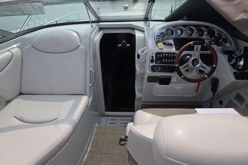 Slide: The Image of 2017 Crownline 325 SCR boat interior with white seating and modern dashboard controls. - 16