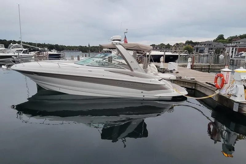 Slide: The Image of 2017 Crownline 325 SCR boat docked at a marina, reflecting on calm water. - 1