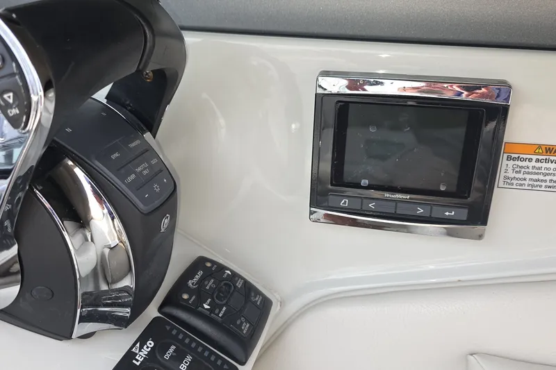Slide: The Image of Control panel of a 2017 Crownline 325 SCR boat with steering wheel and display. - 18