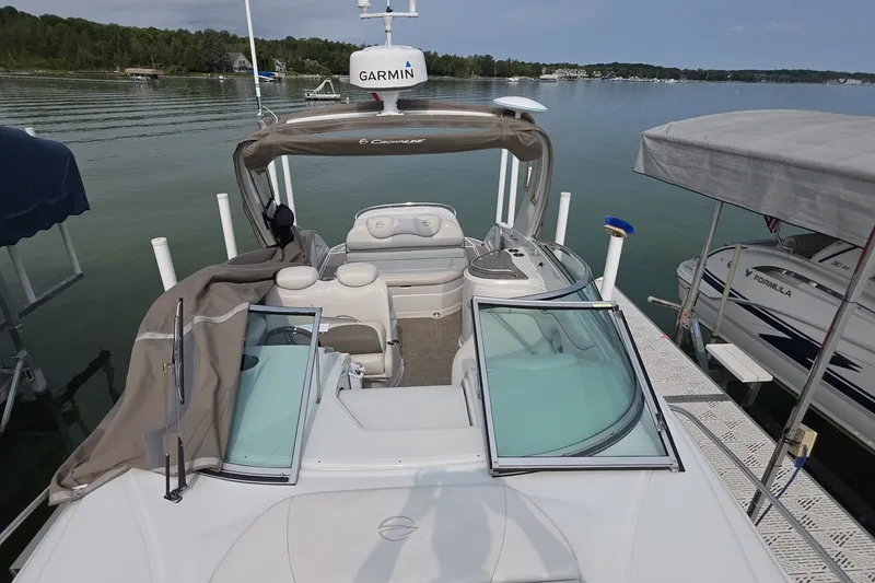 Slide: The Image of 2017 Crownline 325 SCR boat docked on a serene lake with Garmin equipment. - 6