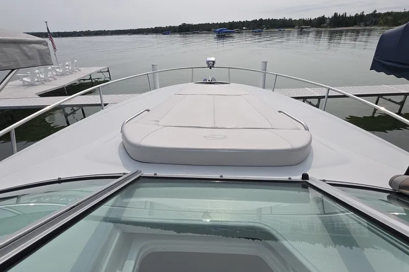 Slide: The Image of 2017 Crownline 325 SCR boat on a calm lake with docks nearby. - 11