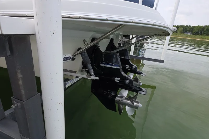 Slide: The Image of 2017 Crownline 325 SCR boat with dual propellers docked on calm water. - 47