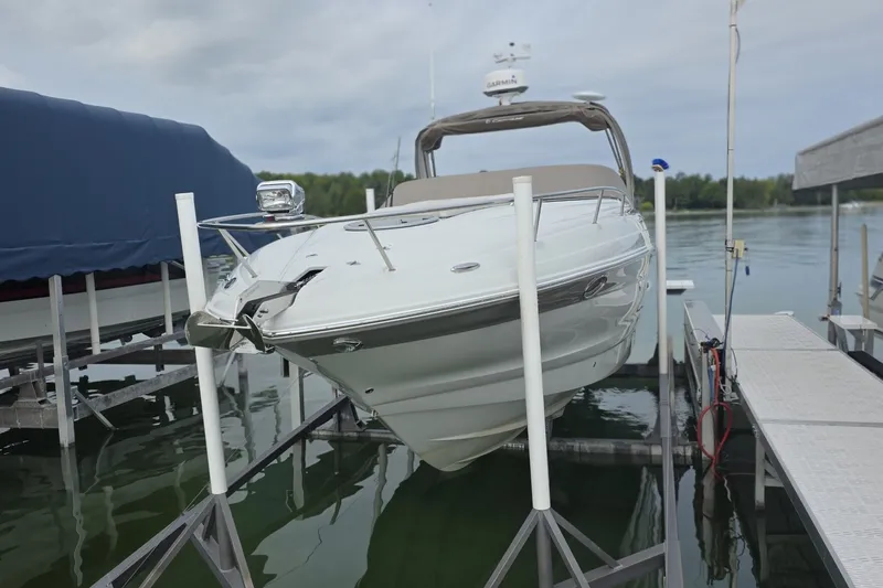 Slide: The Image of 2017 Crownline 325 SCR boat docked on a lift by the water. - 9