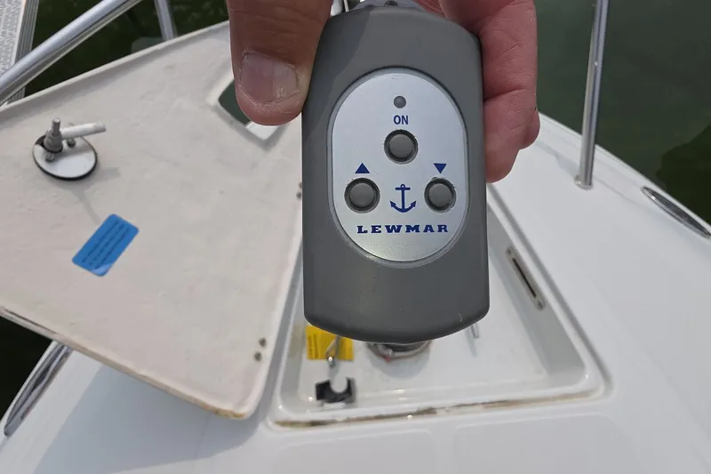 Slide: The Image of Hand holding Lewmar remote on 2017 Crownline 325 SCR boat deck. - 27