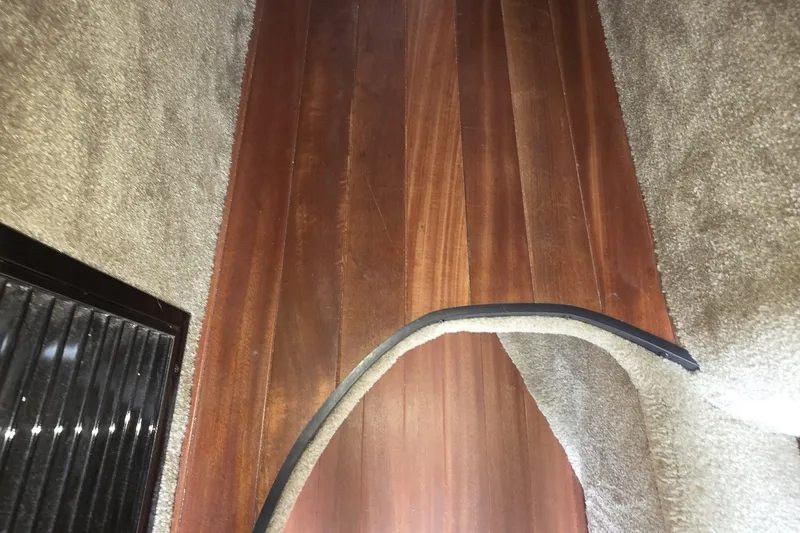 Slide: The Image of Interior view of 2017 Crownline 325 SCR boat with wooden flooring and carpeted sides. - 33