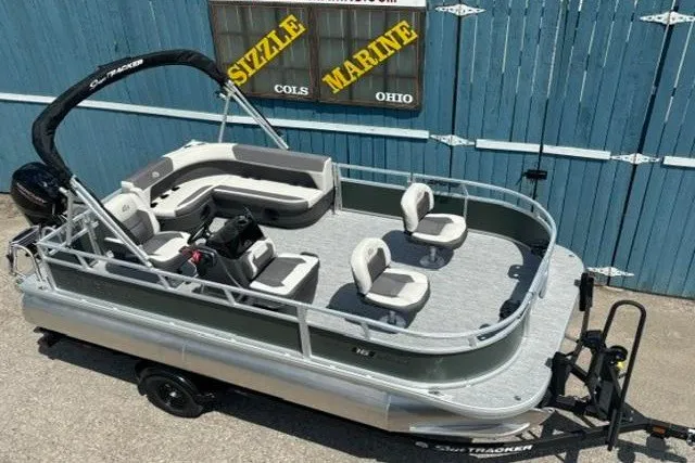 The Image of 2026 Sun Tracker Bass Buggy 16 XL Select pontoon boat on trailer, displayed outdoors. - 0