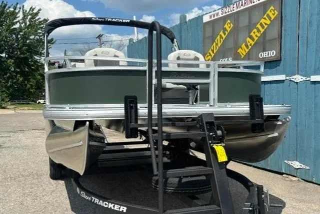 Slide: The Image of 2026 Sun Tracker Bass Buggy 16 XL Select pontoon boat on trailer at Sizzle Marine. - 2