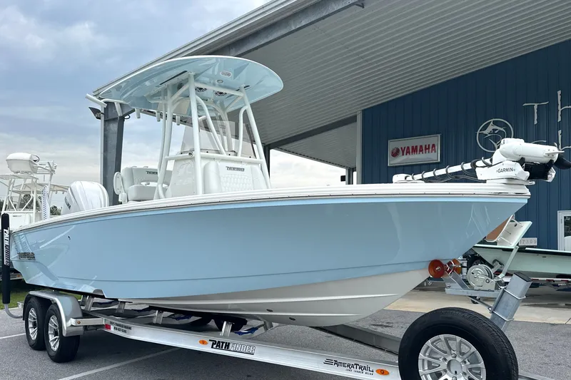 Slide: The Image of 2027 Pathfinder 2400 Tournament boat on trailer, light blue hull, parked at dealership. - 33