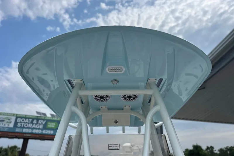 Slide: The Image of 2027 Pathfinder 2400 Tournament boat with T-top and speakers under a cloudy sky. - 10
