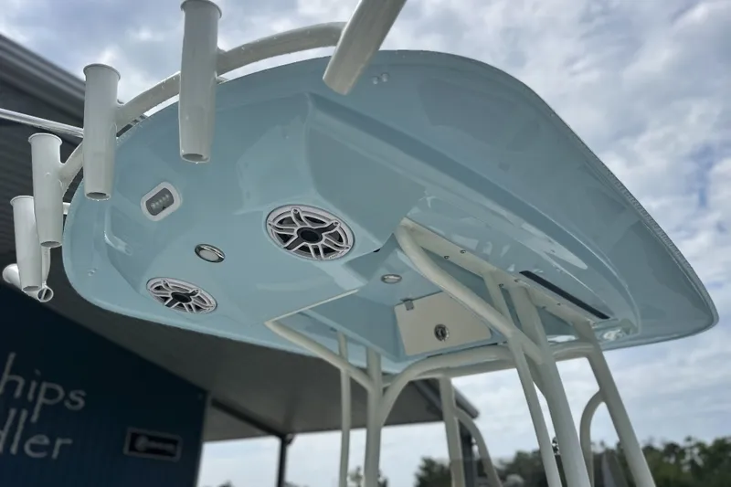 Slide: The Image of 2027 Pathfinder 2400 Tournament boat with rod holders and speakers under a cloudy sky. - 5