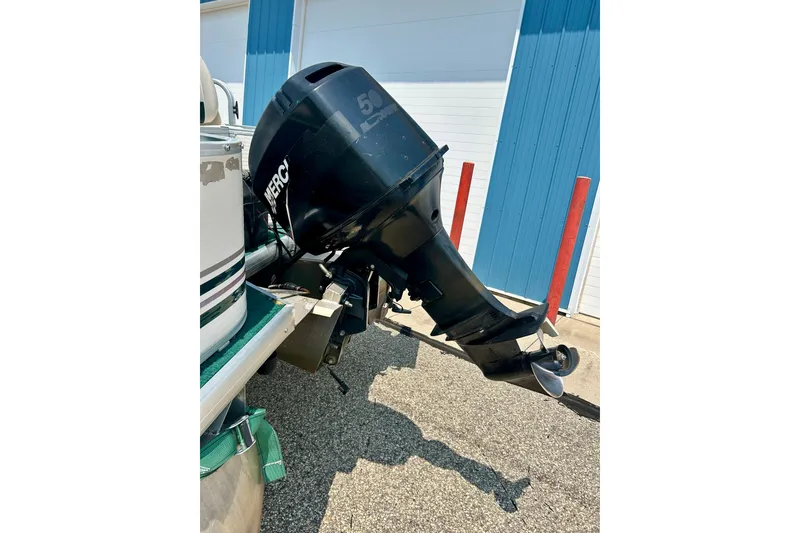 Slide: The Image of 2003 Misty Harbor 2080CF boat with Mercury outboard motor, parked near blue building. - 11