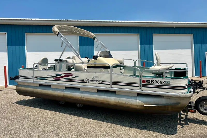 Slide: The Image of 2003 Misty Harbor 2080CF pontoon boat parked near blue building. - 2