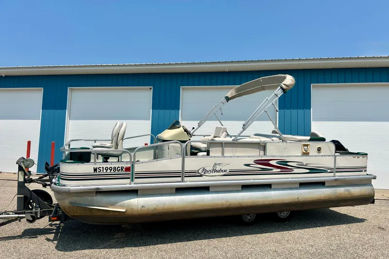 Slide: The Image of 2003 Misty Harbor 2080CF pontoon boat parked outside a blue building. - 1
