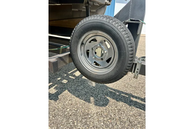 Slide: The Image of Trailer wheel of a 2003 Misty Harbor 2080CF boat on asphalt surface. - 47