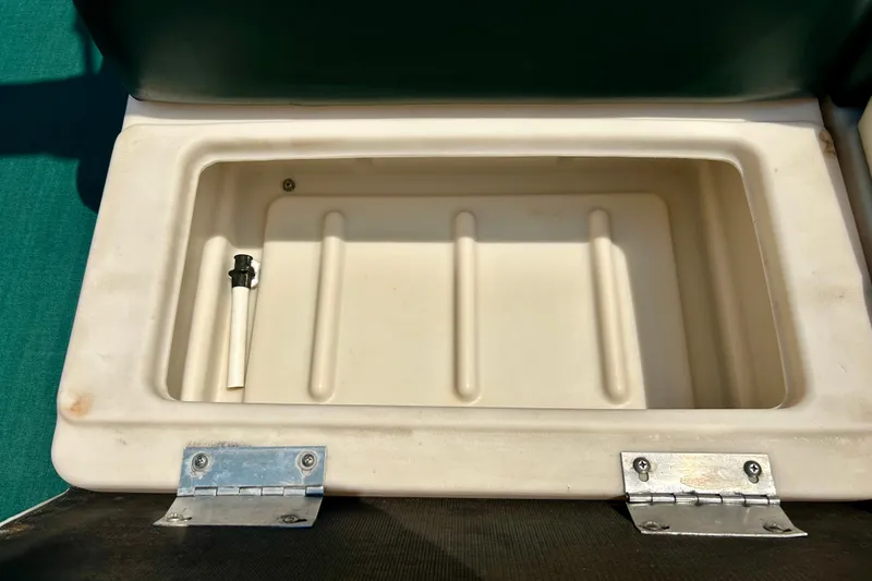 Slide: The Image of Storage compartment of a 2003 Misty Harbor 2080CF boat, featuring a white interior and metal hinges. - 33