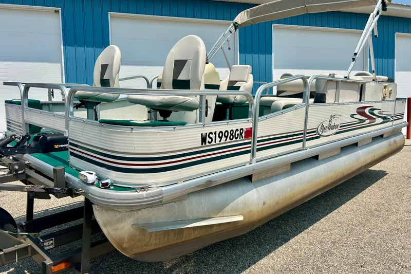 Slide: The Image of 2003 Misty Harbor 2080CF pontoon boat with seating, parked near a blue building. - 5