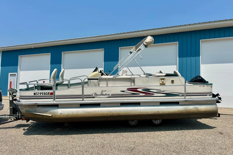 Slide: The Image of 2003 Misty Harbor 2080CF pontoon boat parked outside a blue building. - 3