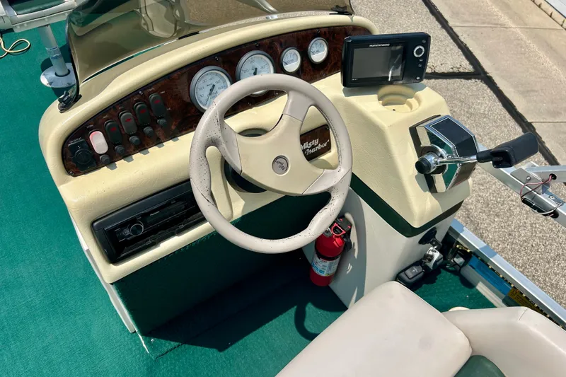 Slide: The Image of 2003 Misty Harbor 2080CF boat dashboard with steering wheel and control panel. - 22