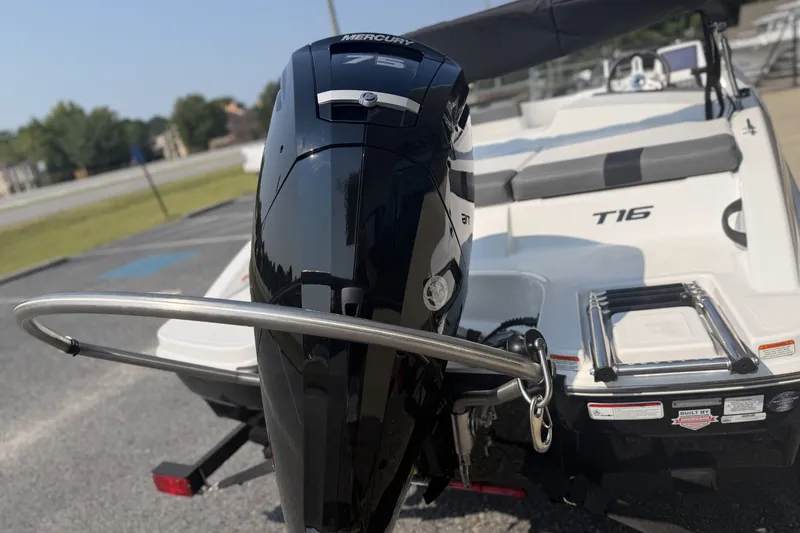 Slide: The Image of 2027 Tahoe T16 boat with Mercury engine, parked outdoors, showcasing sleek design and features. - 2