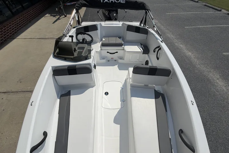 Slide: The Image of 2027 Tahoe T16 boat interior with seating and steering wheel, parked on pavement. - 13