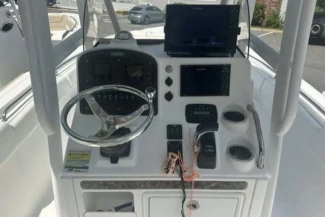 Slide: The Image of 2013 Sea Hunt Ultra 234 boat console with steering wheel and navigation equipment. - 4