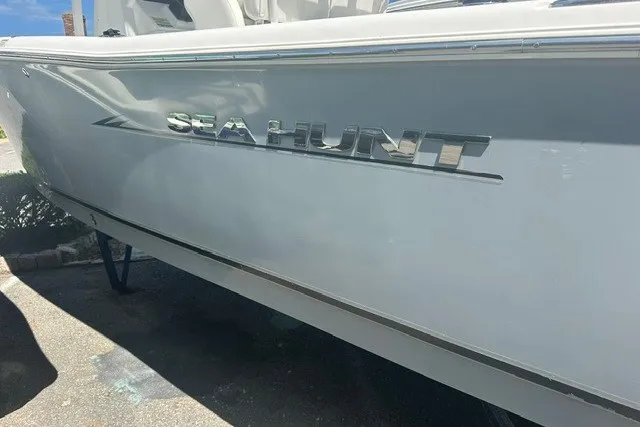 Slide: The Image of 2013 Sea Hunt Ultra 234 boat side view with logo in sunlight. - 2
